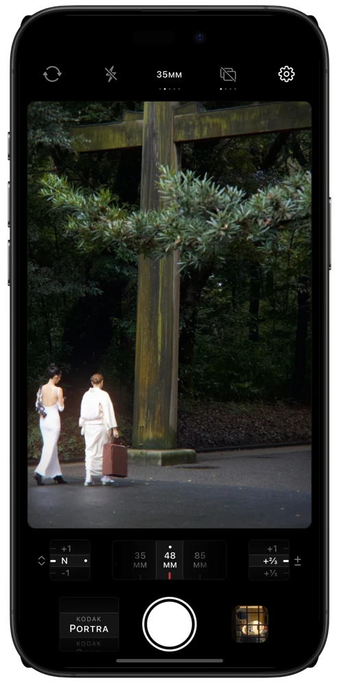 Licht camera interface showing two people near a wooded shrine in the live film viewfinder